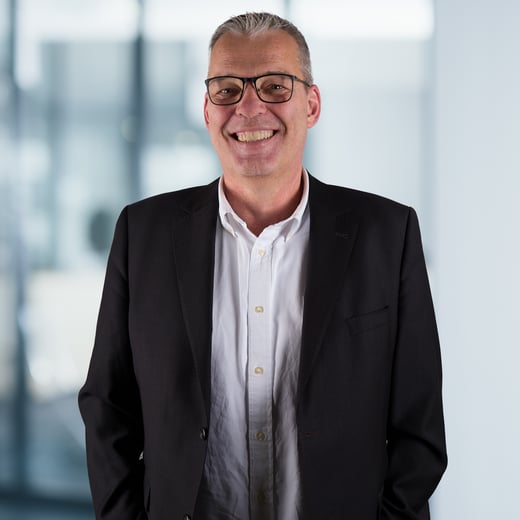 Axel Piepenstock, Leitung Vorsorge, steht vor einem modernen Bürohintergrund. Der Hintergrund ist unscharf, aber zeigt Anzeichen einer Büroumgebung.
